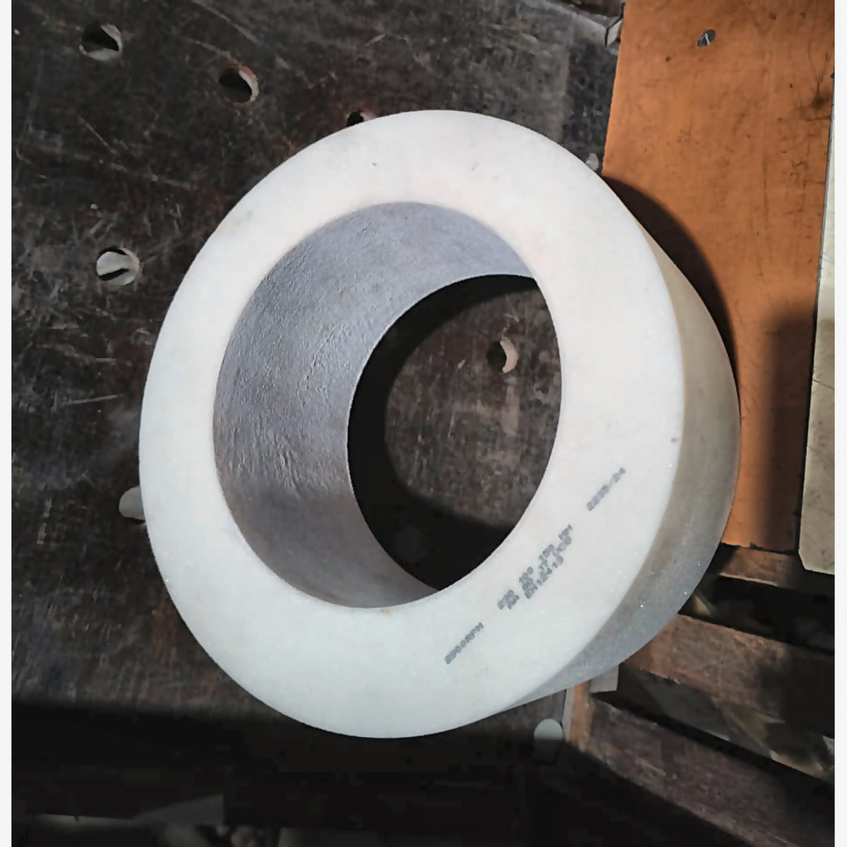 Grinding stone at an angle, showing depth and the printed specification markings